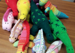 Multicoloured knitted dinosaurs on sale in the museum